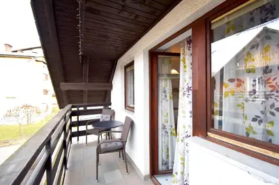 a balcony with chairs and a table and a window at Apartment Kolman in Bohinj