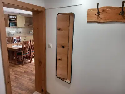 a mirror hanging on a wall next to a kitchen at Apartments Markež in Bohinj