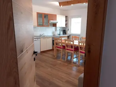 a kitchen and dining room with a table and chairs at Apartments Markež in Bohinj