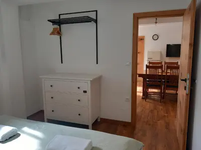 a bedroom with a bed and a dining room at Apartments Markež in Bohinj
