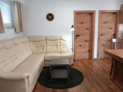 a living room with a white couch and a table at Apartments Markež in Bohinj