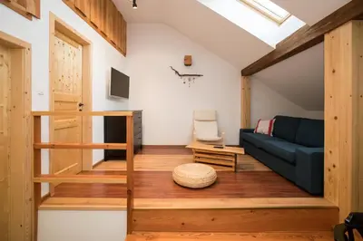 a living room with a blue couch and wooden floors at Apartments Markež in Bohinj