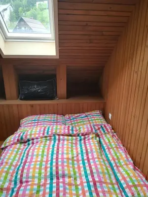 a bed in a small room with a window at Apartma PR PEKOVCU in Bohinj