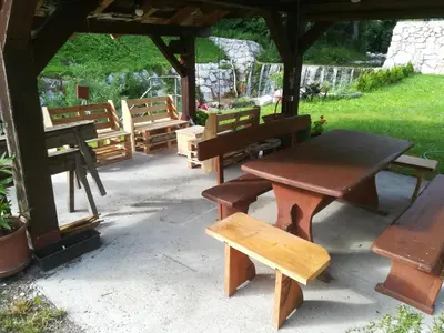 a picnic table and benches under a gazebo at Apartma PR PEKOVCU in Bohinj