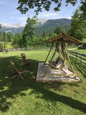 a gazebo and a chair in a field at Holiday House Franc in Srednja Vas v Bohinju