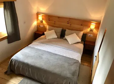 a bedroom with a large bed with two pillows at Holiday House Franc in Srednja Vas v Bohinju