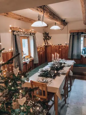 a dining room with a table and a christmas tree at Holiday House Franc in Srednja Vas v Bohinju