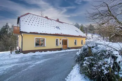a small yellow house with snow on the side of a road at Robida in Vransko