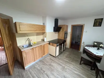 a kitchen with wooden cabinets and a table in a room at Robida in Vransko