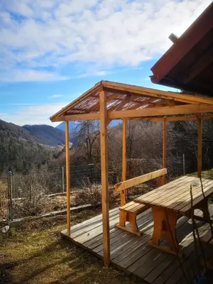 a wooden picnic table on a deck with a view at Robida in Vransko
