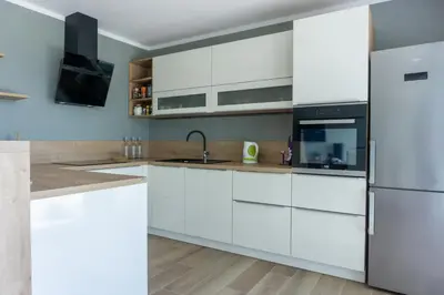 a kitchen with white cabinets and a refrigerator at Nature View House with Sauna in Tolmin