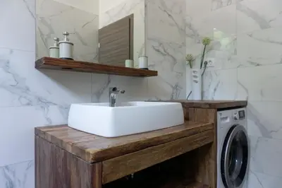 a bathroom with a sink and a washing machine at Nature View House with Sauna in Tolmin