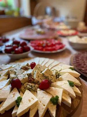 a table with cheese and strawberries and plates of food at Turistična kmetija Čerček in Solčava