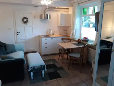 a living room with a table and a kitchen at Pletna Lake View Apartment (Ground Floor) in Bled
