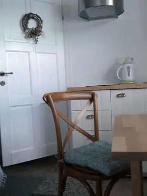 a wooden chair in a kitchen with a table at Pletna Lake View Apartment (Ground Floor) in Bled