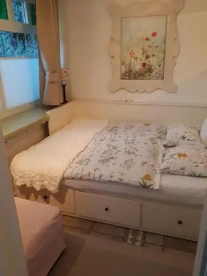 a bed in a room with a painting on the wall at Pletna Lake View Apartment (Ground Floor) in Bled