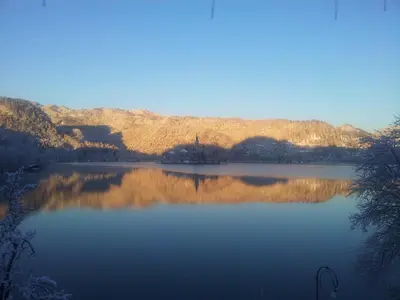 a view of a lake with mountains in the background at Pletna Lake View Apartment (Ground Floor) in Bled