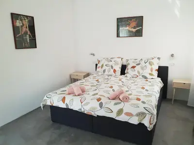 a bedroom with a bed with pink slippers on it at Resort Vidmar near Bled - rooms Vidmar in Lesce
