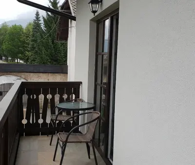 a balcony with a table and chairs and a window at Resort Vidmar near Bled - rooms Vidmar in Lesce