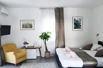a bedroom with two beds and a chair at Resort Vidmar near Bled - rooms Vidmar in Lesce