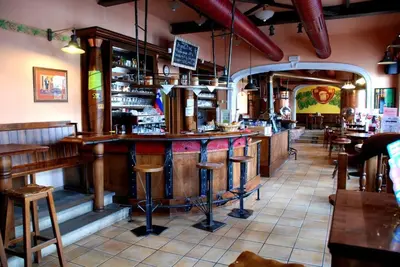 a bar in a restaurant with tables and stools at Hotel Zvezda in Murska Sobota
