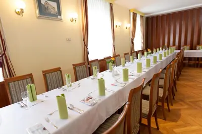 a long table in a room with tables and chairs at Hotel Zvezda in Murska Sobota