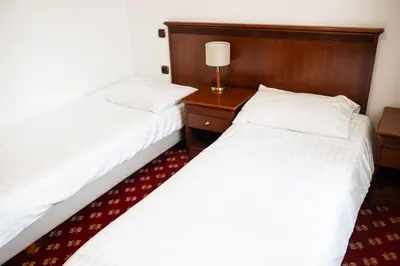 two beds sitting next to each other in a room at Hotel Zvezda in Murska Sobota