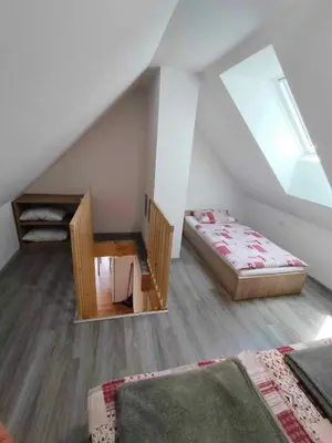 a attic room with a bed and a table in it at Farmhouse Soklic in Bohinj