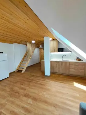 a living room with a wooden ceiling and a staircase at Farmhouse Soklic in Bohinj