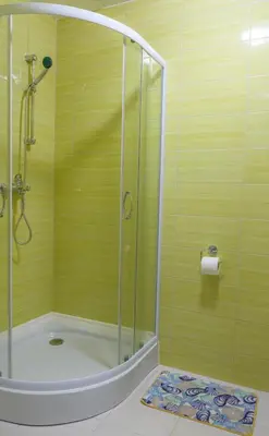 a shower with a glass door in a bathroom at Apartmaji SLATENIK in Bovec