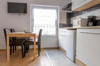 a kitchen with a table and chairs and a window at Apartmaji SLATENIK in Bovec