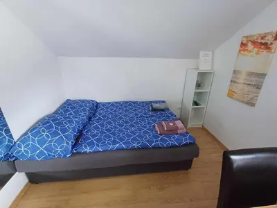 a bed with a blue comforter and a purse on it at Apartmaji SLATENIK in Bovec