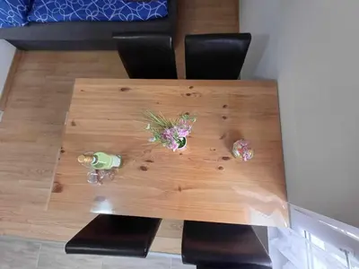 a wooden table with chairs and flowers on it at Apartmaji SLATENIK in Bovec