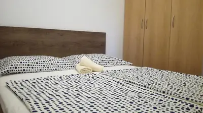a bed with a black and white comforter at Appartma Katja in Gabrovica pri Črnem Kalu