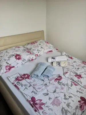 a bed with a floral bedspread and two pillows on it at Appartma Katja in Gabrovica pri Črnem Kalu