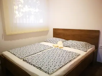 a bed with a white bow on top of it at Appartma Katja in Gabrovica pri Črnem Kalu
