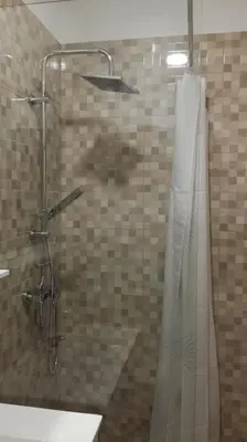 a shower with a glass door with a shower curtain at Appartma Katja in Gabrovica pri Črnem Kalu