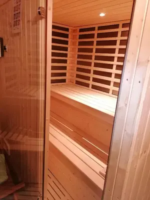 a wooden sauna with a wooden floor and a glass door at Vila Salamander in Štanjel