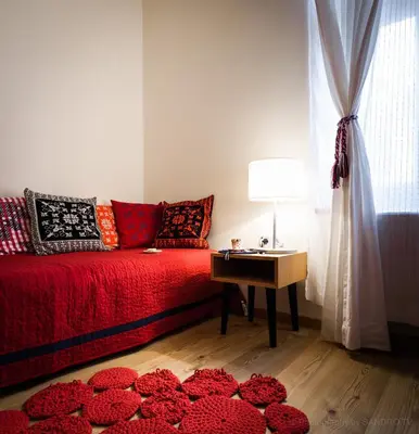 a living room with a red couch and a table with a lamp at Pr'Gavedarjo Eco Heritage B&B in Kranjska Gora