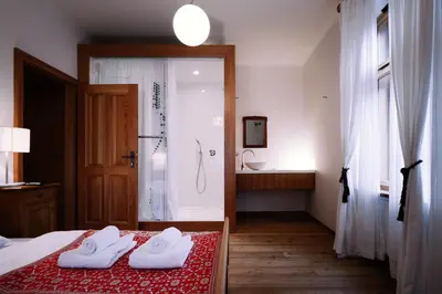 a bedroom with a shower and a bed with two towels at Pr'Gavedarjo Eco Heritage B&B in Kranjska Gora