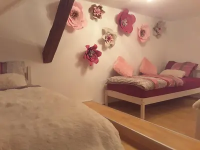 a bedroom with a bed and flowers on the wall at DELUX duplex apartment in Maribor