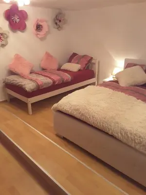 a bedroom with two beds and a bench on the wall at DELUX duplex apartment in Maribor
