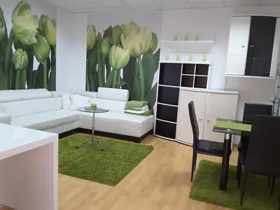 a living room with a white couch and a kitchen at DELUX duplex apartment in Maribor