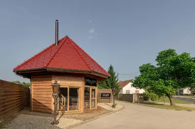 a small wooden building with a red roof at Wellness hiska Izabela in Križevci pri Ljutomeru