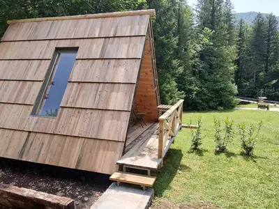 a large wooden cabin with a porch and a window at Lepa Lopa resort in Stahovica