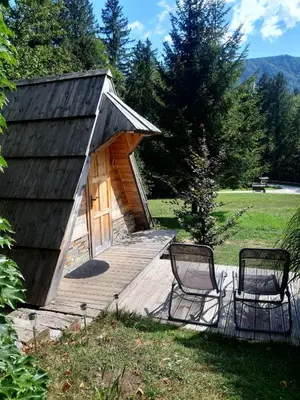 two chairs on a wooden deck with a building at Lepa Lopa resort in Stahovica