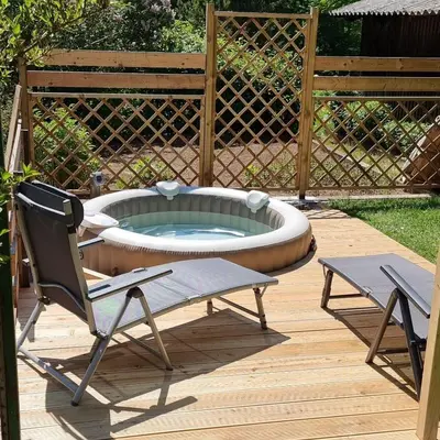 a patio with a hot tub and two chairs at Lepa Lopa resort in Stahovica