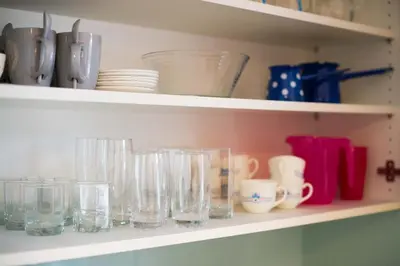 a shelf filled with glasses and plates and cups at Apartma Ela in Bled