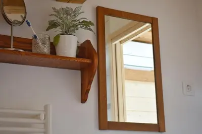 a mirror on a wall next to a shelf at Apartma 10th Mountain, Bovec in Bovec