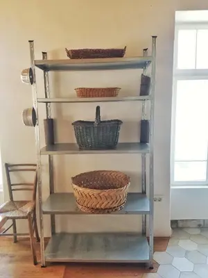 a metal shelving unit with baskets on it at Apartma 10th Mountain, Bovec in Bovec